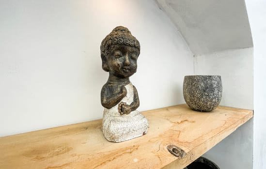 Small statue decorations for table and interior, little buddha statue modern simplistic house environment with several pottery and wooden table
