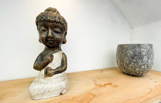 Small statue decorations for table and interior, little buddha statue modern simplistic house environment with several pottery and wooden table