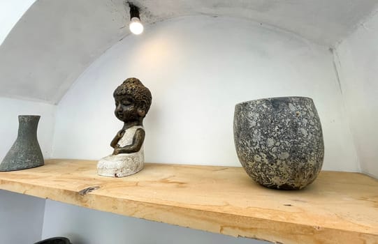 Small statue decorations for table and interior, little buddha statue modern simplistic house environment with several pottery and wooden table