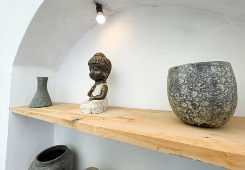 Small statue decorations for table and interior, little buddha statue modern simplistic house environment with several pottery and wooden table