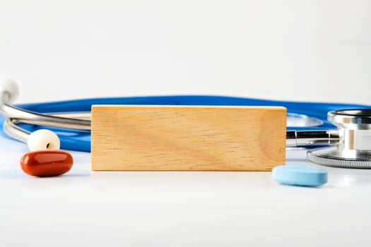 A wooden block in close-up on a white background next to a stethoscope. A place to copy