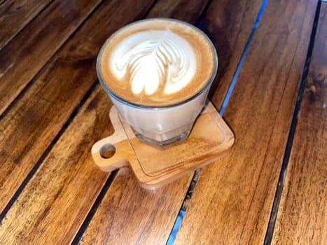 beautiful cup of cappuccino coffee with latte art in the wooden space background