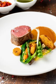 Filet mignon served with vegetables and sauces at a fine dining restaurant