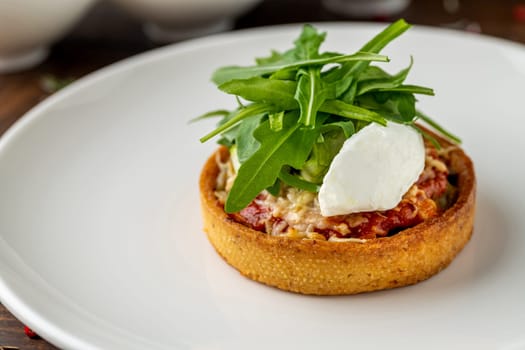 Italian dish Tortino di Verdure served on a white plate on wooden table