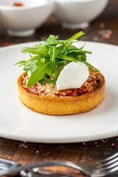 Italian dish Tortino di Verdure served on a white plate on wooden table