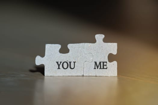 Macro photo of two jigsaw puzzles with you and me words on it. Love or friendship concept. . High quality photo
