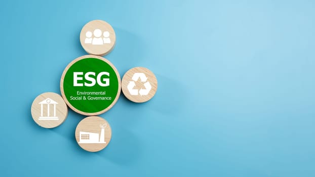 ESG concepts for sustainable environment, society and governance Businesses are environmentally responsible, A circular wooden board with the abbreviation ESG printed on a light blue background.