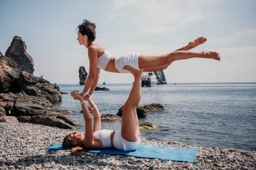 Woman sea yoga. Back view of free calm happy satisfied woman with long hair standing on top rock with yoga position against of sky by the sea. Healthy lifestyle outdoors in nature, fitness concept.