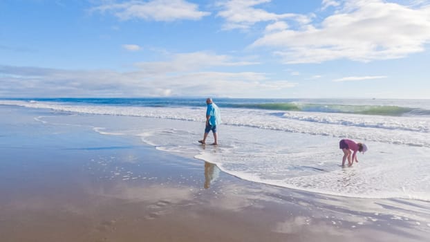 In California, a father and daughter share a serene winter walk along the deserted sands of El Capitan State Beach.