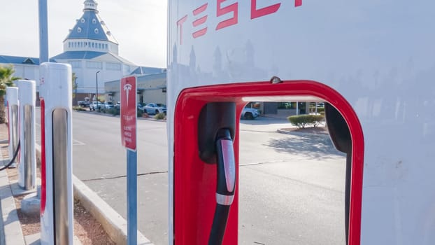 Primm, Nevada, USA-December 3, 2022-During the day, a Tesla vehicle is seen charging at a Tesla Supercharging station, utilizing the high-speed charging infrastructure for convenient and efficient electric vehicle refueling.