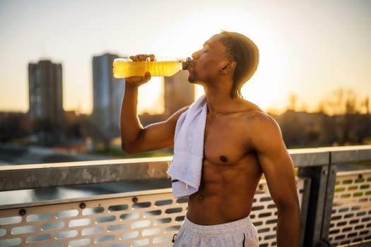 Portrait of young man who is drinking water and relaxing after jogging.