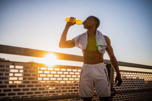 Portrait of young  man who is drinking water and relaxing after jogging.
