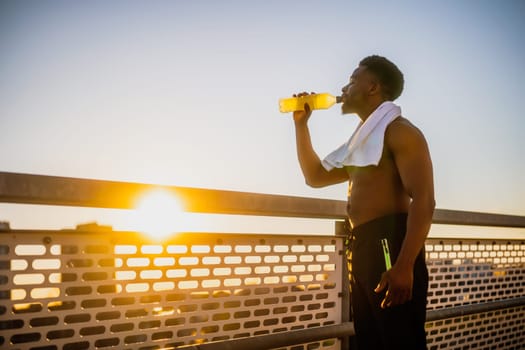 Portrait of young  man who is drinking water and relaxing after jogging.