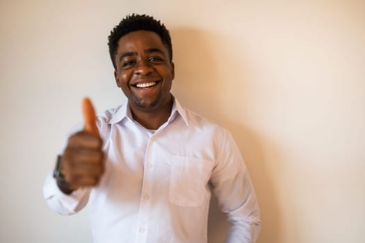 Portrait of happy man who is smiling and showing thumbs up. Copy space on image for your text or advert.