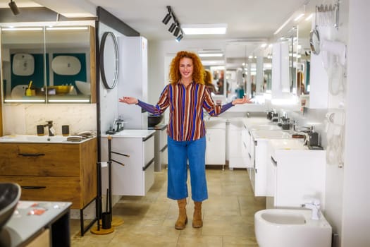 Portrait of salesperson in bathroom store. Happy redhead woman works in bath store. Sales occupation.