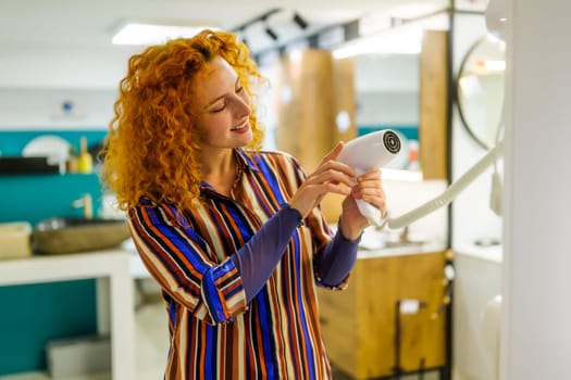 Portrait of buyer in bathroom store. Redhead woman is choosing equipment for her bathroom.