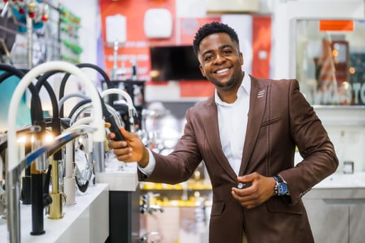 Portrait of buyer in bathroom store. Man is choosing faucet for his apartment.