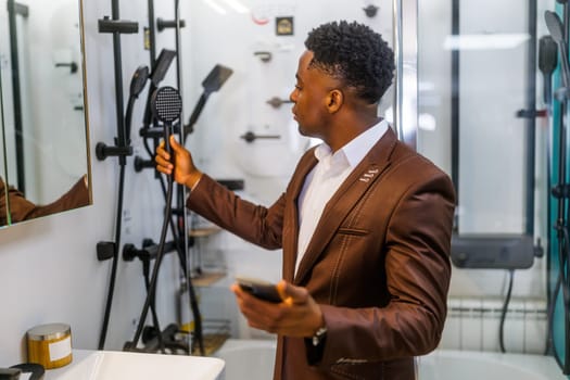 Portrait of buyer in bathroom store. Man is choosing bathtub for his apartment.