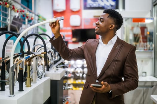 Portrait of buyer in bathroom store. Man is choosing faucet for his apartment.