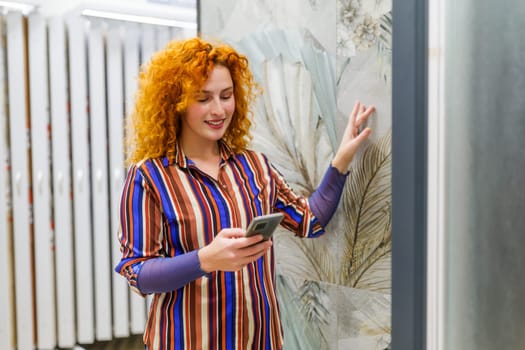 Portrait of buyer in bathroom store. Redhead woman is choosing tiles for her apartment.