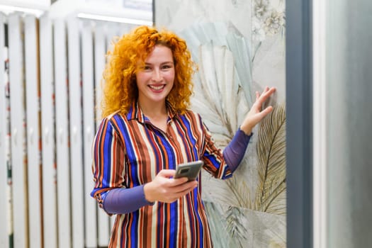 Portrait of buyer in bathroom store. Redhead woman is choosing tiles for her apartment.