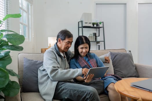 Retired elderly couple looking at tablet phone together, shopping online, surfing website together.