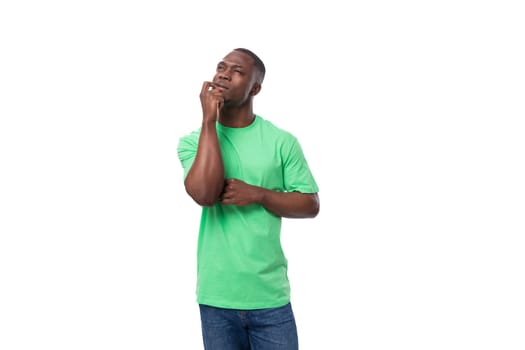 A 30-year-old American man dressed in a light green basic T-shirt looks up thoughtfully.