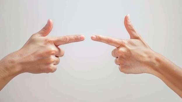 Two hands pointing at each other with thumbs up