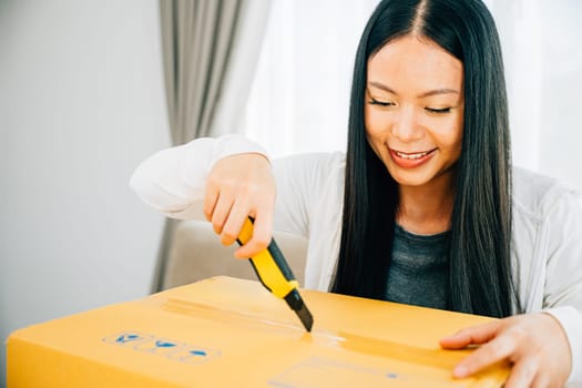 A woman opens a mock-up package with a utility cutter revealing online shopping contents. Engaged in precision unboxing unpacking and discovering. Retail and surprise concept.