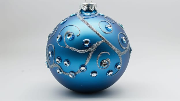 A blue ornament with a silver design on it