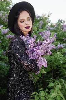 A fashionable girl with dark hair, a spring portrait in lilac tones in summer. Bright professional makeup