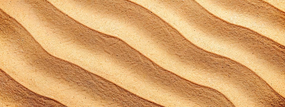 Close-up of the detailed sandy dunes texture with natural wavy patterns and earth tones, perfect for background, wallpaper, or abstract nature surface in a warm, arid outdoor environment