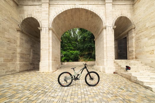 Freestanding mountain bike against the backdrop of architectural arches. MTB cover concept.