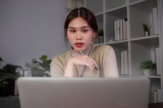 Asian female student studying online Video calls through Zoom about business administration and accounting subjects attentively.