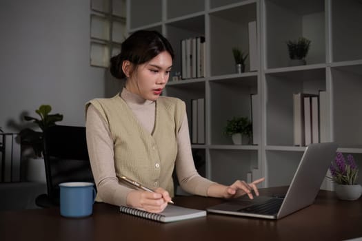 Asian female student studying online Video calls through Zoom about business administration and accounting subjects attentively.