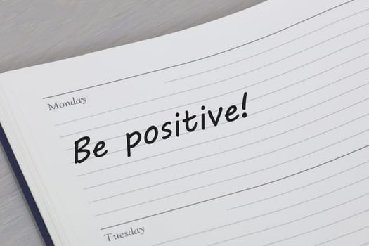 A Be positive reminder message in an open diary