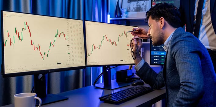 Stock exchange traders looking on high profit chart investment in panorama view, analyzing on monitor at night. Concept of discussing financial technology growth in neon light at workplace. Sellable.