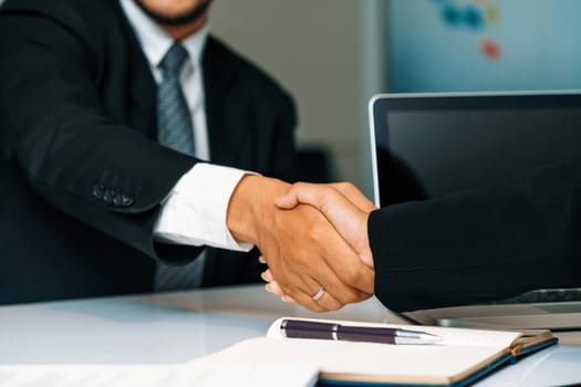 Business people agreement concept. Businessman and Asian businesswoman do handshake in the office. uds