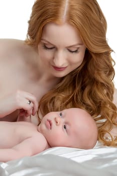 Image of pretty red-haired mother takes care of her baby