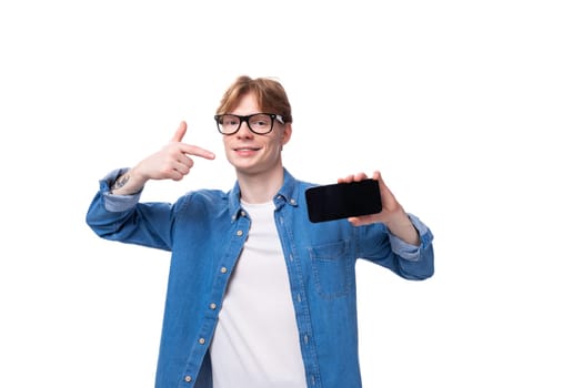 young cheerful red-haired guy dressed in a blue shirt over a t-shirt.