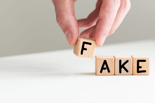 Concept for fake news. Cubes placed on a newspaper form the word FAKE. High quality photo