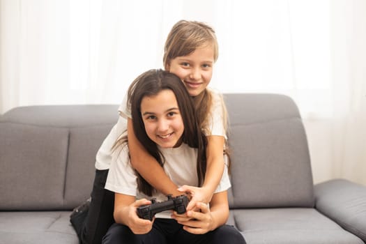 Two middle school girls at home playing an exciting video game together. High quality photo