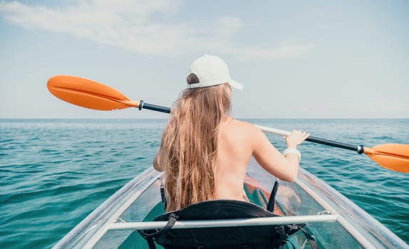 Woman in kayak back view. Happy young woman with long hair floating in transparent kayak on the crystal clear sea. Summer holiday vacation and cheerful female people having fun on the boat.