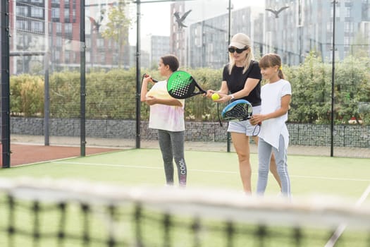 mother and daughters playing padel outdoor. High quality photo