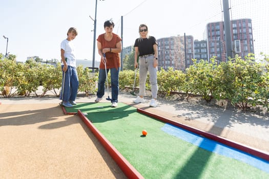 family playing mini golf on a cruise liner. Child having fun with active leisure on vacations. High quality photo