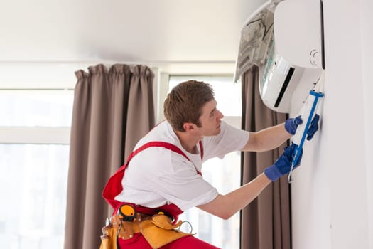 technician service checking and repairing air conditioner indoors.
