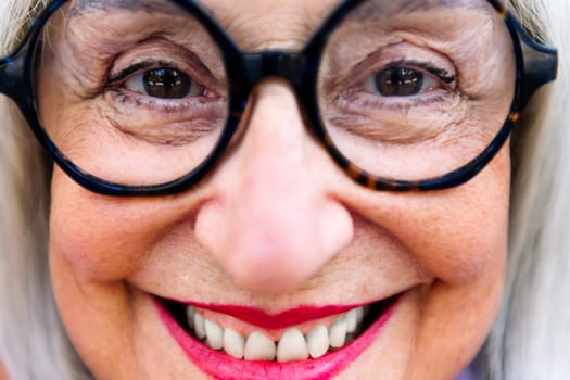 close-up portrait of a beautiful senior woman smiling happy looking at camera, concept of elderly people happiness and active lifestyle