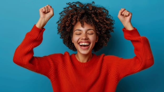 A woman in a red sweater celebrating with her hands up