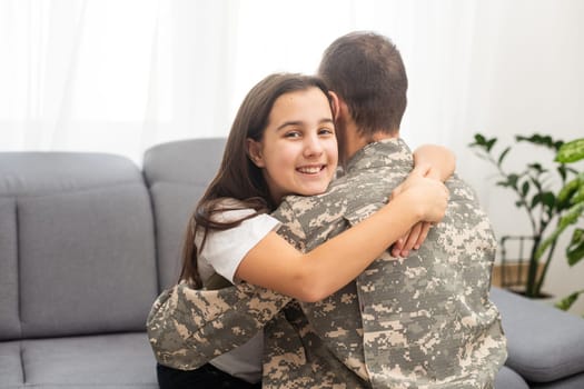 Young man in military uniform with his wife on sofa at home. High quality photo