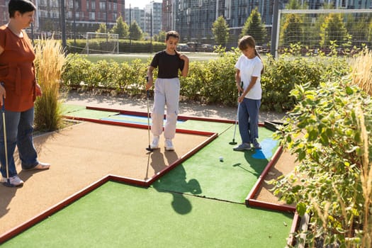 golfers with parents playing golf at sunny day. High quality photo